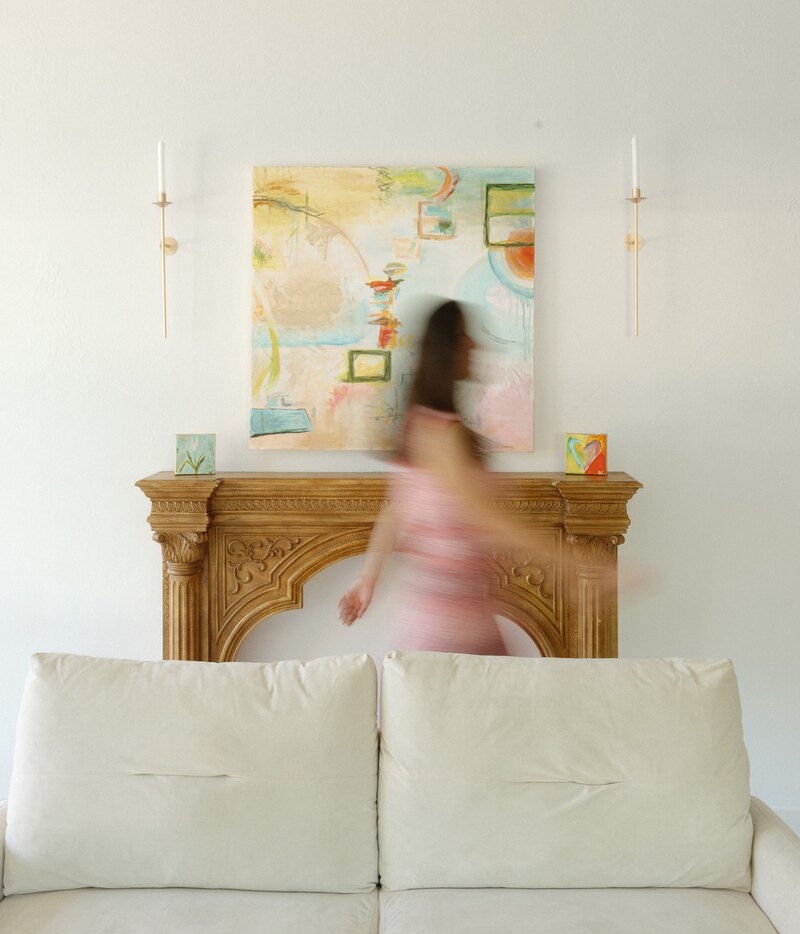 Gracie Crabtree walking through her studio beside her artwork
